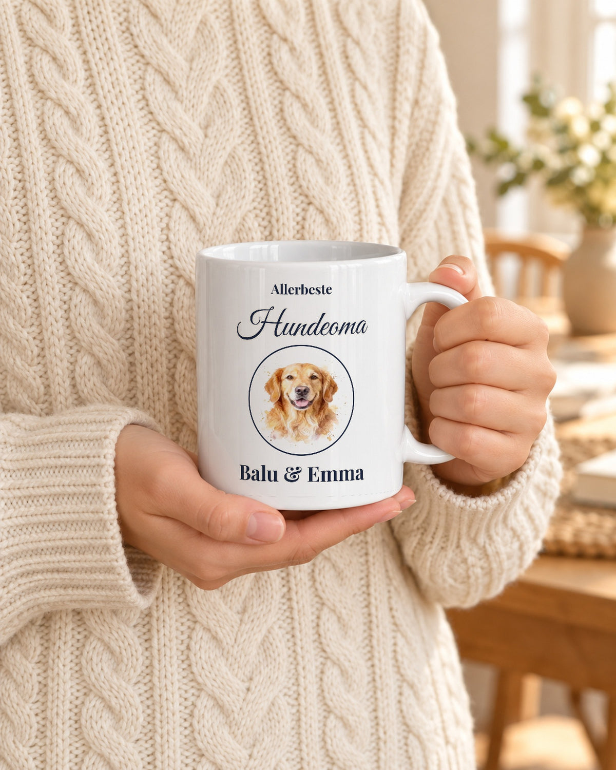 Weiße Tasse mit Hundeportrait im Aquarell-Stil, „Allerbeste Hundeoma“ und Namen, gehalten von Händen im Strickpulli