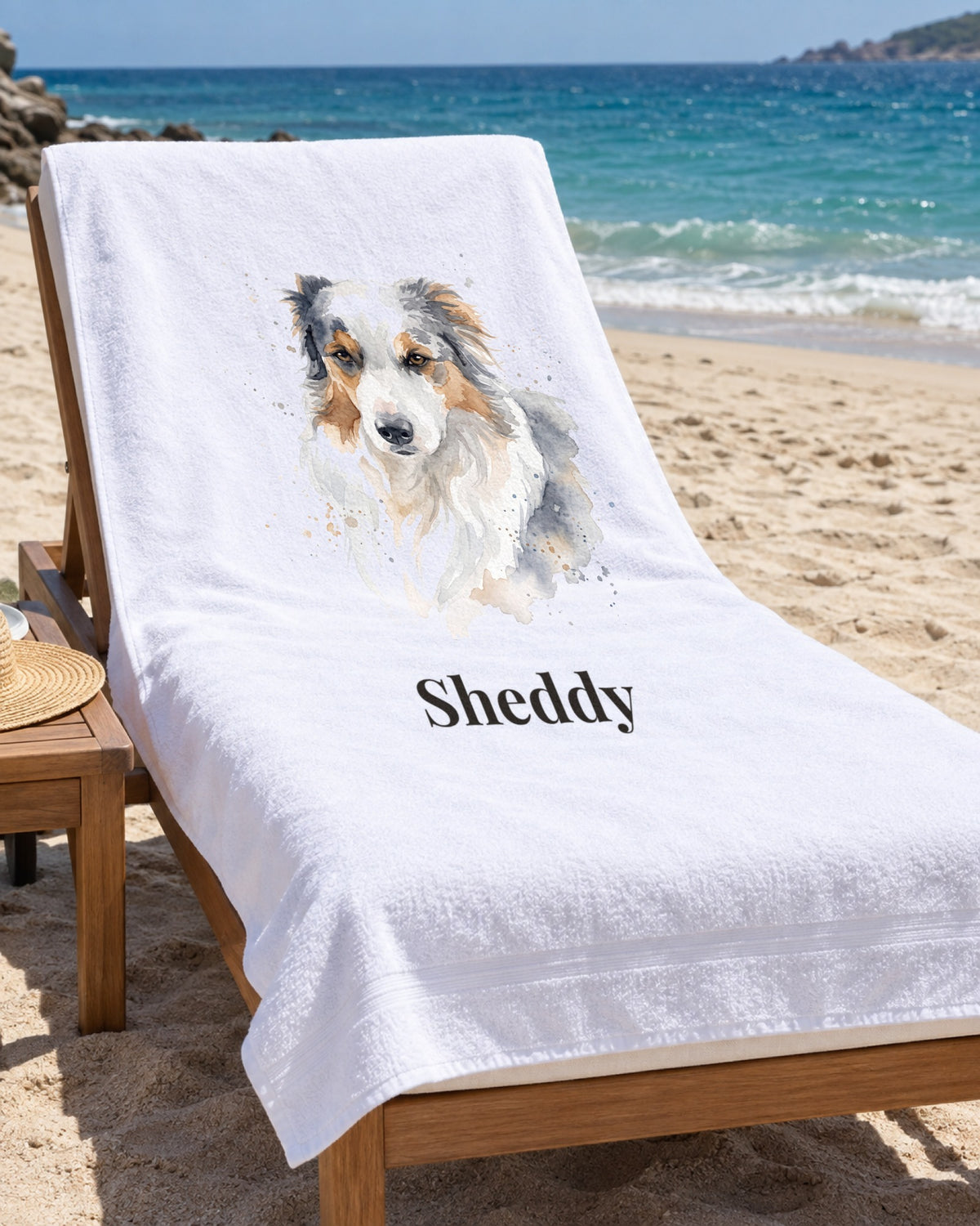 Weißes Badetuch mit Hundeportrait im Stil Aquarell und dem Namen Sheddy auf einer Strandliege