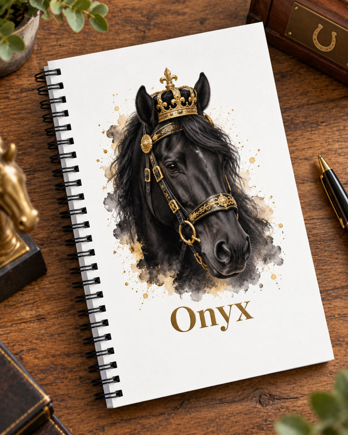Notizbuch mit Spiralbindung, Rappe im Royal-Stil mit Krone und Namen Onyx liegt auf einem dunklen Holztisch