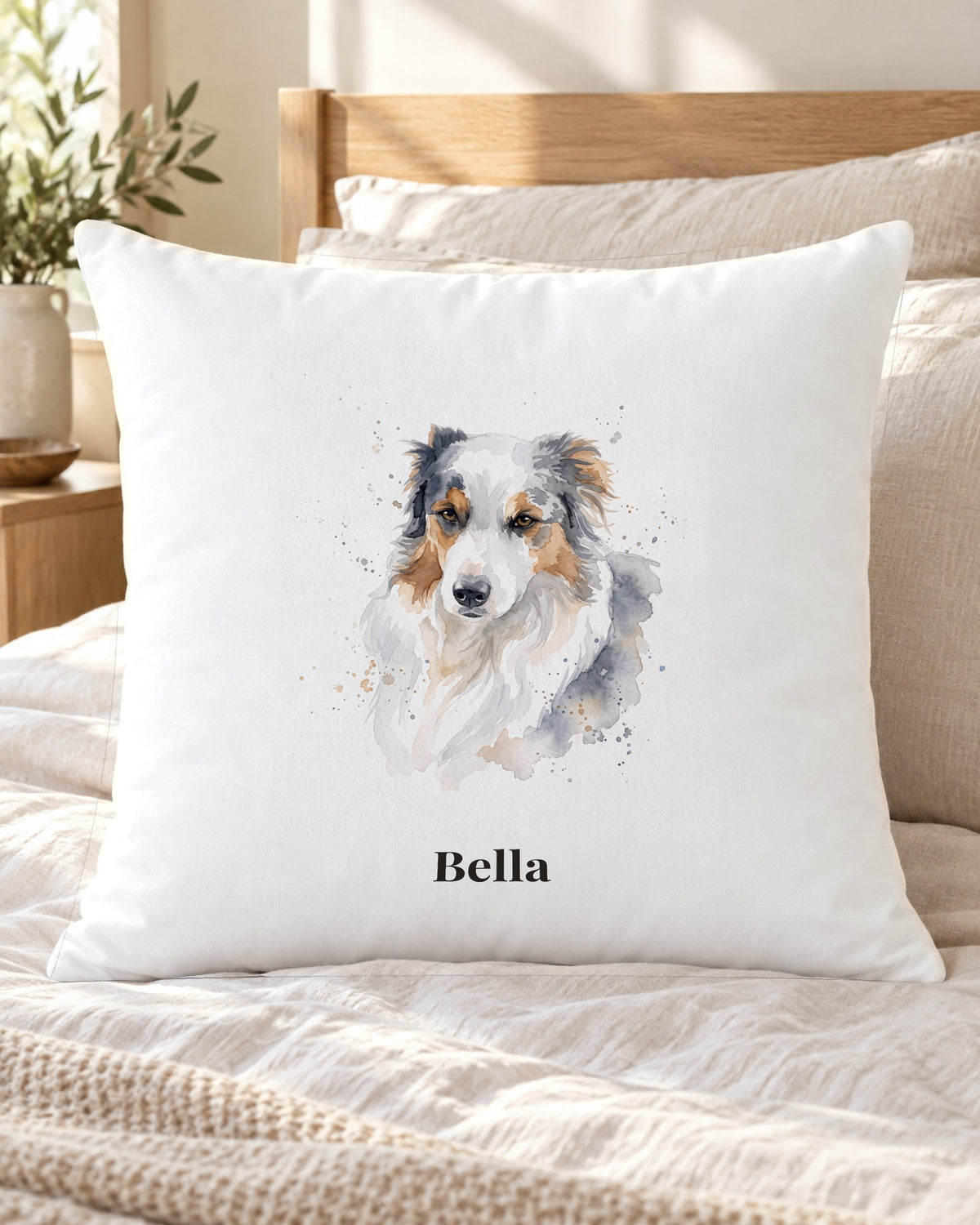 Kissenbezug mit Hundeportrait im Aquarell-Stil und Namen Bella auf dem Bett