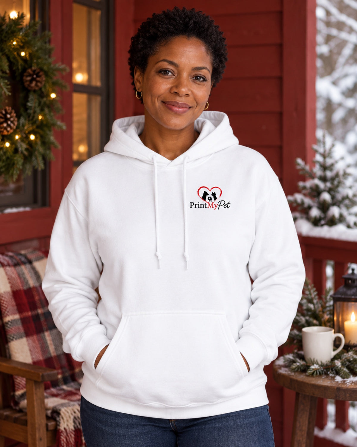 Frau im weißen PrintMyPet Edition Hund Hoodie mit kleinem Logo auf der linken Brust auf einer dunkelroten Winterveranda