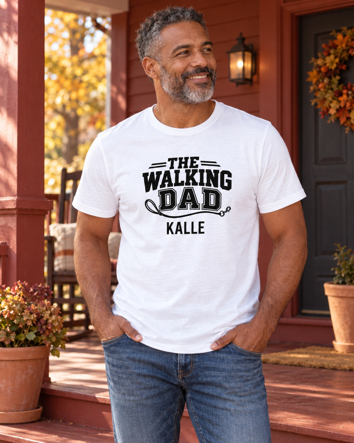 Mann im weißen The Walking Dad T-Shirt mit Beispielname Kalle auf einer rostroten Herbstveranda