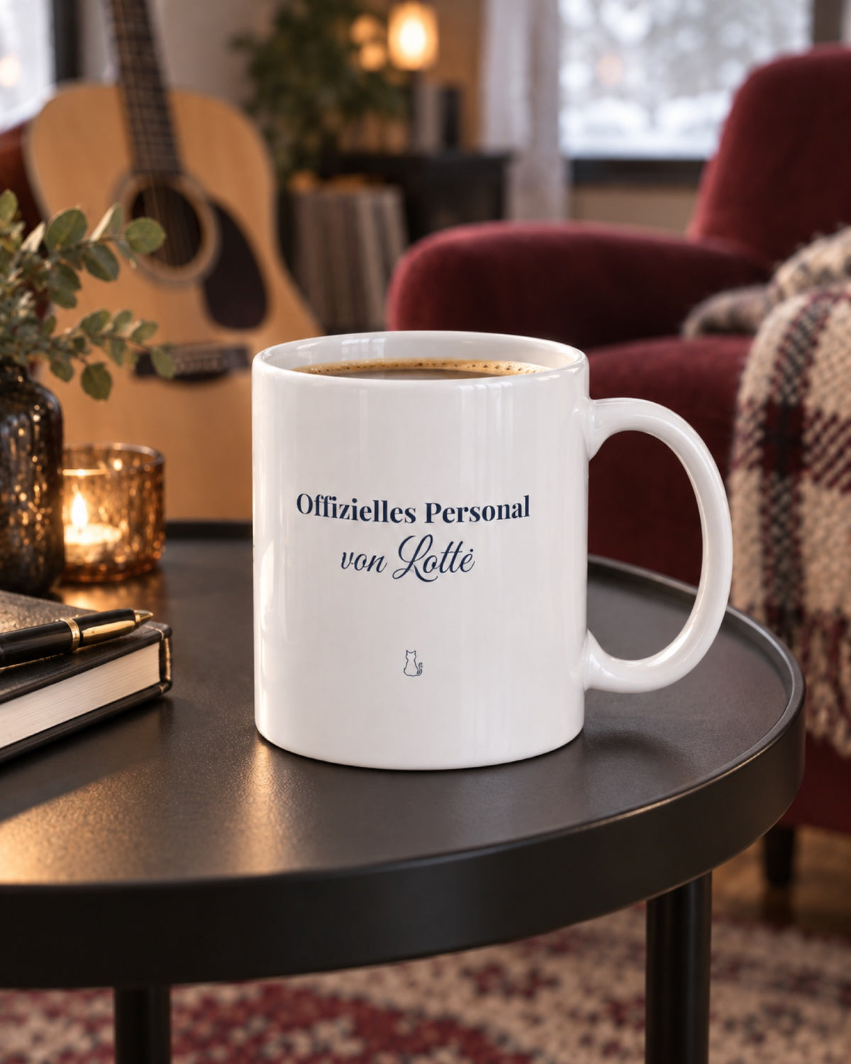 Weiße Keramiktasse Spruchtasse für Katzenmenschen auf einem schwarzen Beistelltisch im Musikzimmer mit Beispielname Lotte